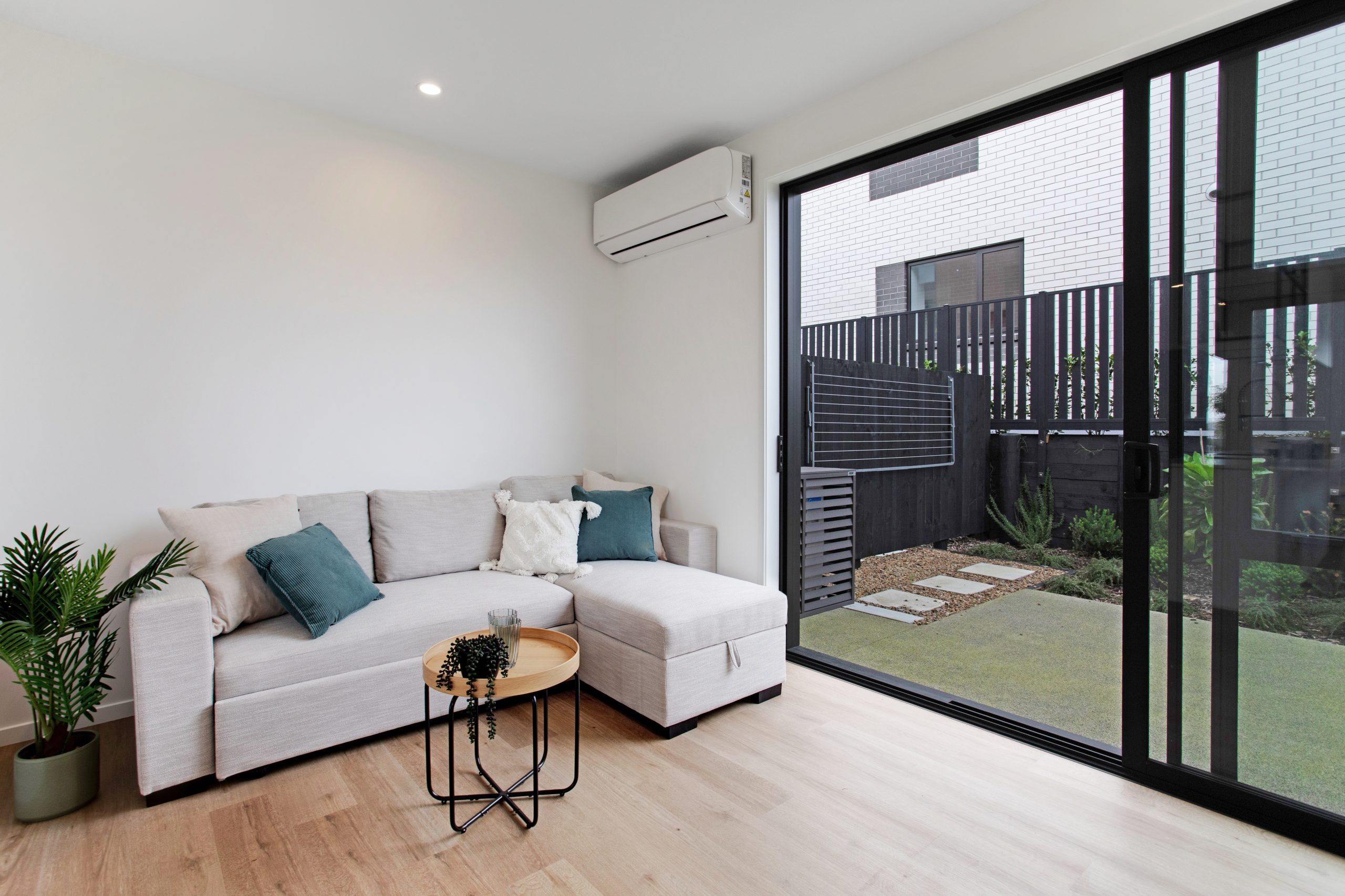 Lounge with couch, sliding door open to the outside patio